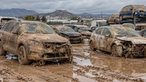 Vehiculos inundados por una DANA cubiertos de barro y pendientes de valoracion pericial
